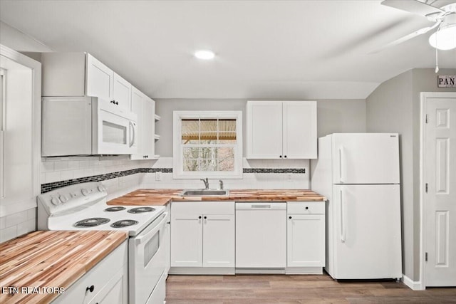 kitchen with white cabinets, butcher block counters, and white appliances