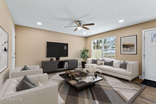 living area featuring baseboards, a ceiling fan, wood finished floors, and recessed lighting