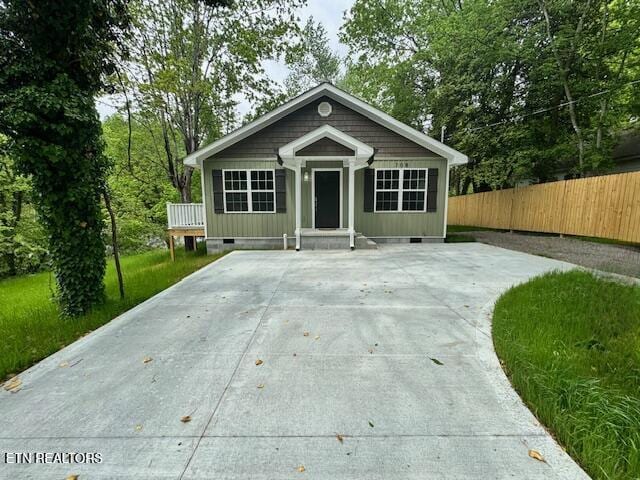 bungalow-style home with fence and crawl space