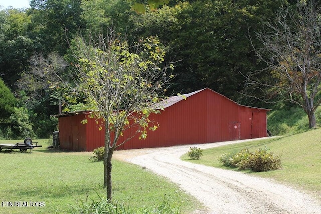 view of side of property with a lawn and an outdoor structure