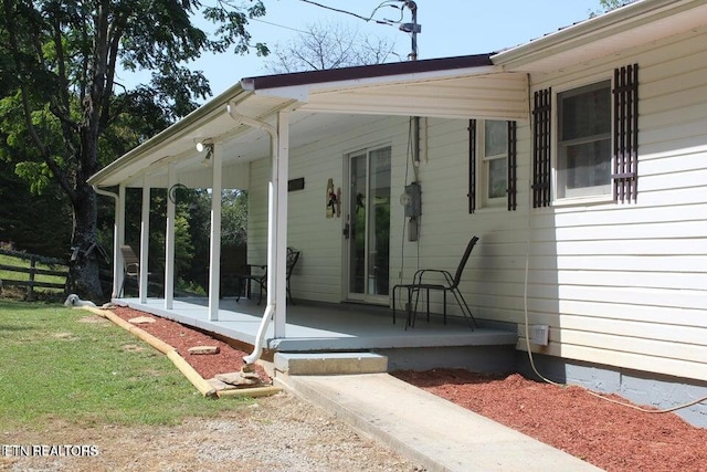 view of exterior entry featuring covered porch