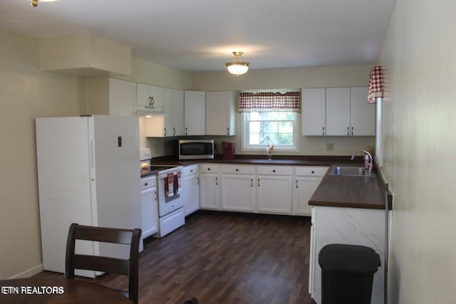 kitchen with sink, white cabinets, dark wood-type flooring, and white appliances