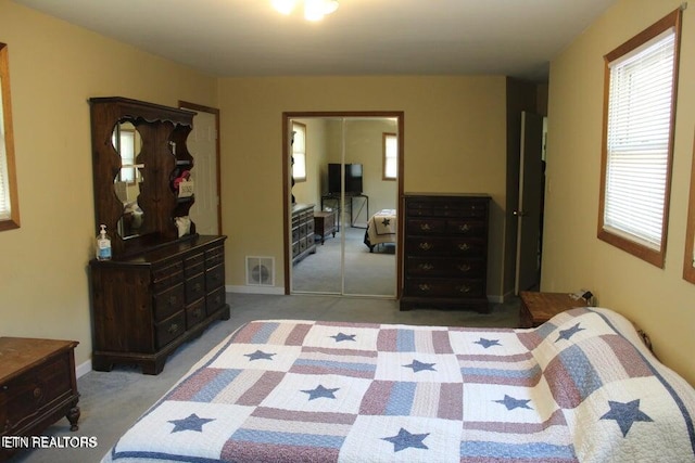 bedroom featuring light carpet and a closet