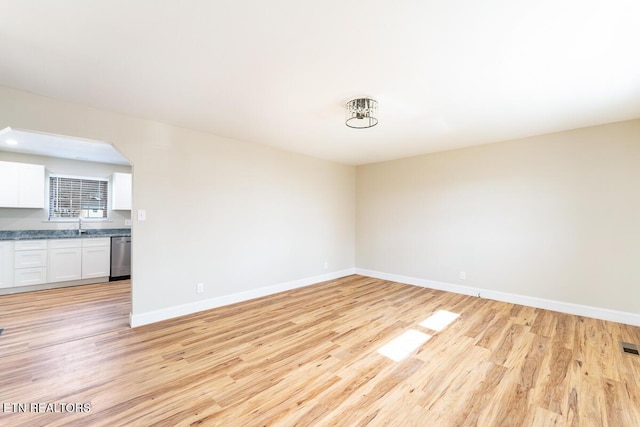 empty room with light hardwood / wood-style flooring and sink