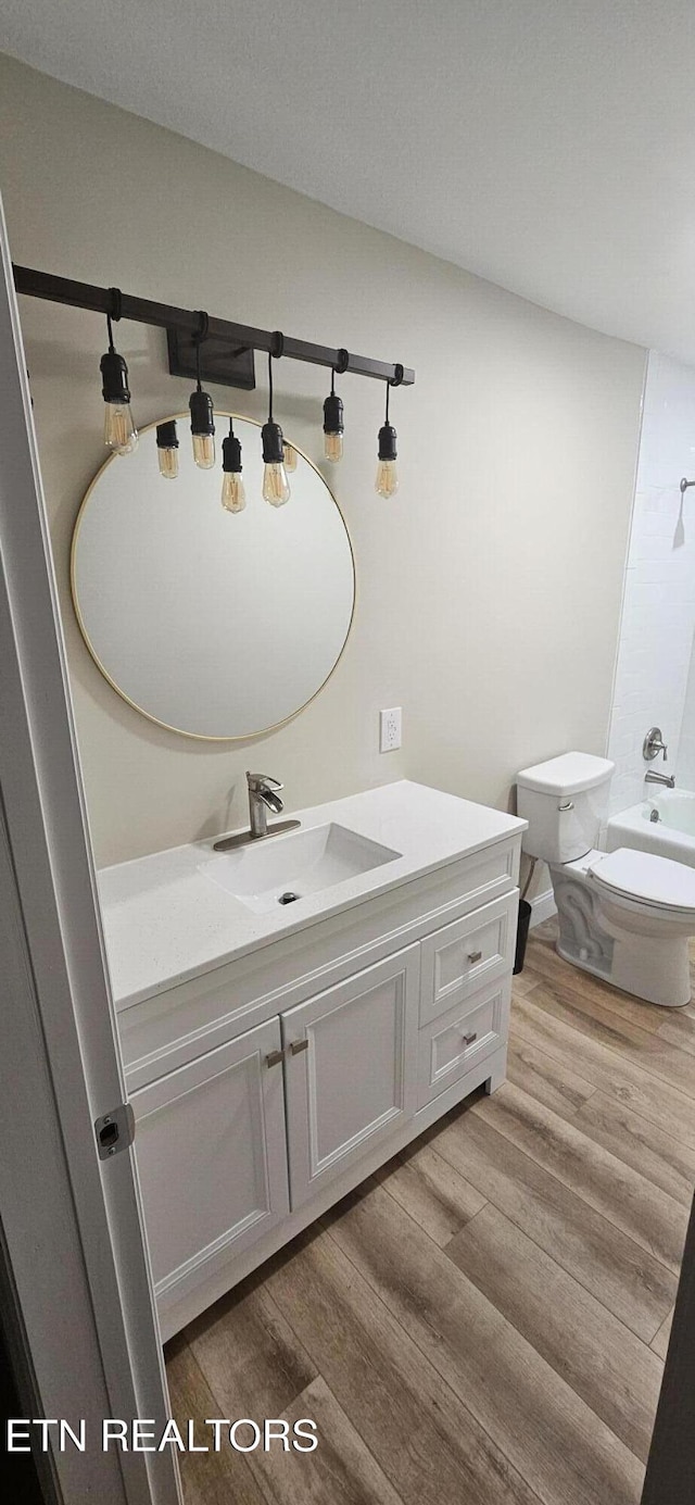 full bathroom featuring vanity, toilet, wood-type flooring, and bathtub / shower combination