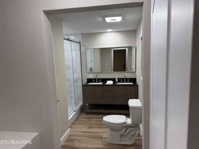 bathroom featuring hardwood / wood-style floors, vanity, an enclosed shower, and toilet