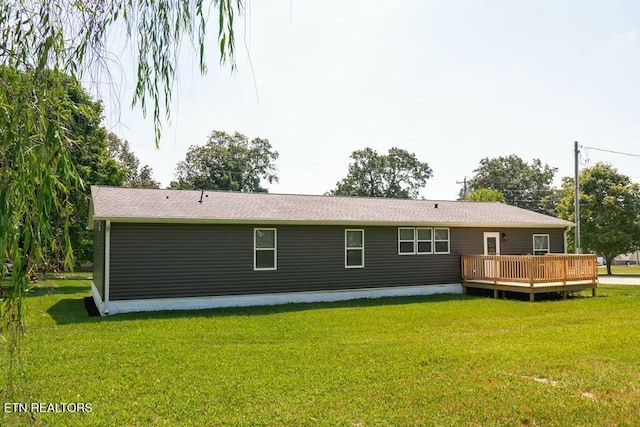 rear view of property featuring a deck and a yard