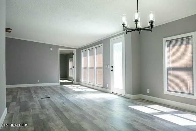 empty room featuring hardwood / wood-style flooring, a notable chandelier, crown molding, and vaulted ceiling