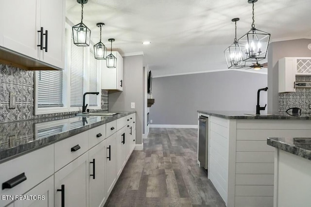 kitchen featuring dark wood-type flooring, white cabinets, sink, decorative backsplash, and decorative light fixtures