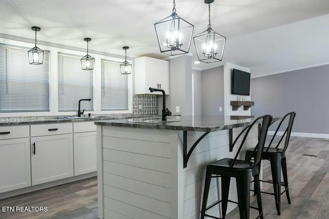 kitchen with pendant lighting, dark hardwood / wood-style floors, white cabinetry, and a kitchen island