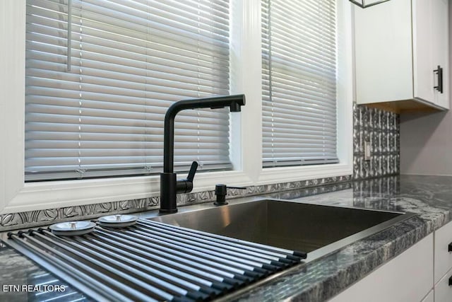 interior details featuring white cabinets and sink