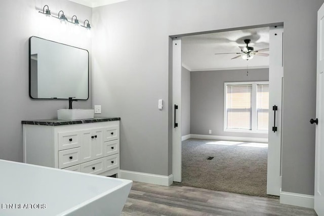 bathroom featuring ceiling fan, a bathtub, vanity, and hardwood / wood-style flooring