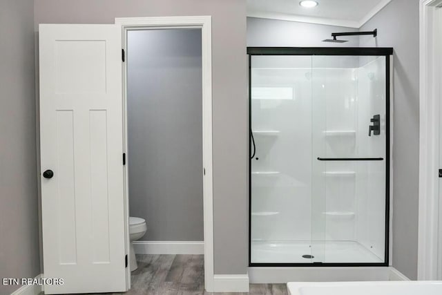 bathroom with hardwood / wood-style flooring, toilet, and walk in shower