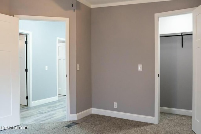 unfurnished bedroom featuring light carpet and a closet