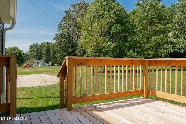 wooden terrace featuring a yard