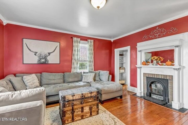 living room featuring a fireplace, wood-type flooring, and ornamental molding