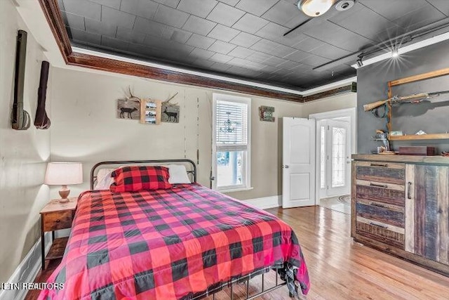 bedroom with hardwood / wood-style floors and ornamental molding