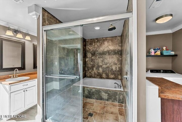 bathroom featuring washer and clothes dryer, vanity, independent shower and bath, and ornamental molding