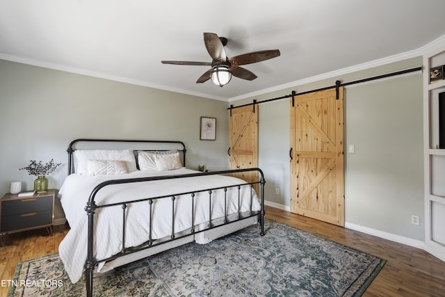 bedroom with ceiling fan, a barn door, ornamental molding, and dark hardwood / wood-style floors