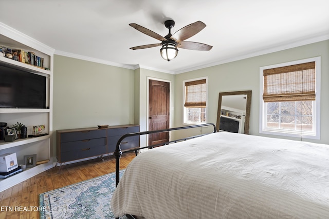 bedroom with multiple windows, crown molding, ceiling fan, and dark wood-type flooring