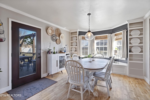 dining space featuring light hardwood / wood-style floors and crown molding