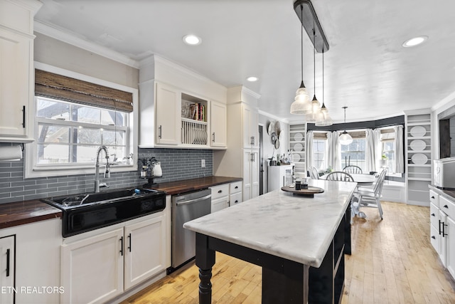 kitchen featuring white cabinetry, dishwasher, sink, a center island, and decorative light fixtures