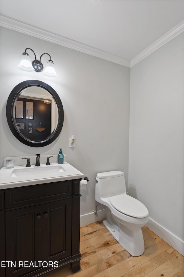 bathroom featuring vanity, hardwood / wood-style flooring, toilet, and ornamental molding