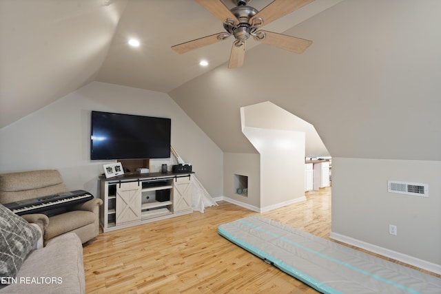 living room with ceiling fan, light hardwood / wood-style floors, and vaulted ceiling