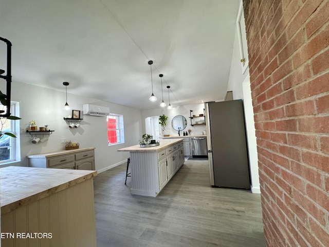 kitchen featuring decorative light fixtures, a center island, stainless steel appliances, and brick wall