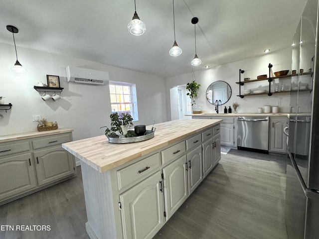 kitchen featuring butcher block counters, dishwasher, an AC wall unit, pendant lighting, and a kitchen island