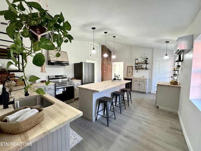 kitchen with a breakfast bar, sink, gray cabinets, appliances with stainless steel finishes, and a wall unit AC