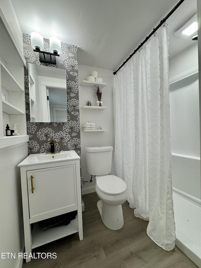 bathroom with hardwood / wood-style floors, vanity, and toilet