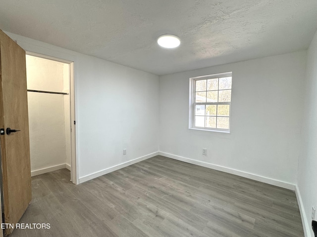 empty room with a textured ceiling and hardwood / wood-style flooring