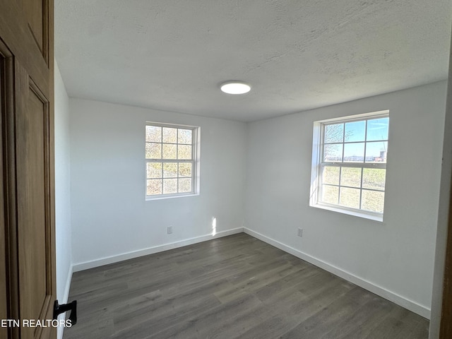 spare room with dark wood-type flooring and a textured ceiling