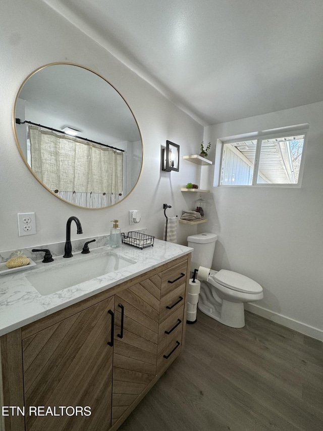 bathroom with vanity, wood-type flooring, and toilet