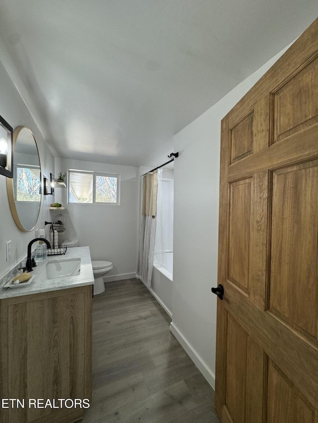 full bathroom featuring wood-type flooring, vanity, toilet, and shower / tub combo with curtain