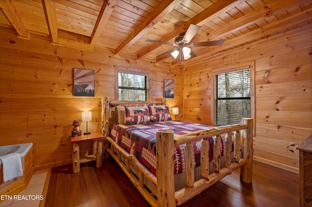 bedroom featuring wood walls, wood ceiling, hardwood / wood-style flooring, beamed ceiling, and ceiling fan