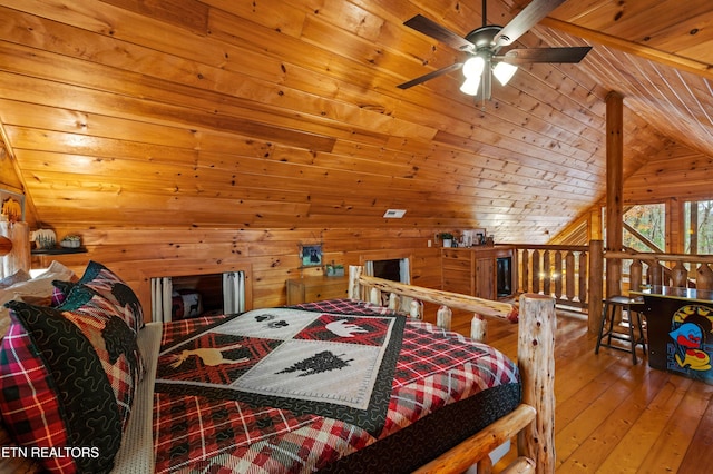 bedroom with hardwood / wood-style floors, wood walls, lofted ceiling, ceiling fan, and wooden ceiling