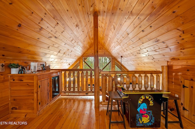 interior space with vaulted ceiling, wooden ceiling, light hardwood / wood-style floors, and wood walls