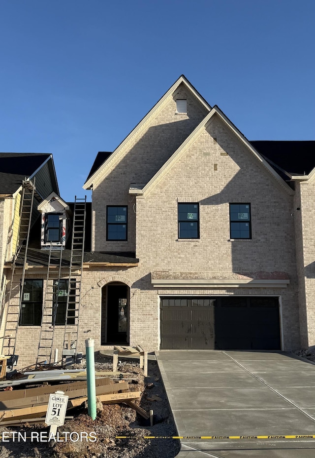 view of front of home featuring concrete driveway, brick siding, and an attached garage