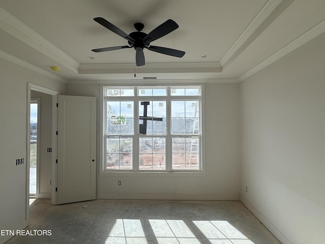 empty room with plenty of natural light, a raised ceiling, and crown molding