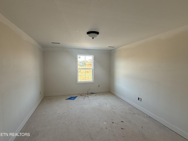 unfurnished room featuring baseboards and a textured ceiling