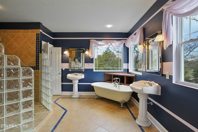 full bathroom featuring walk in shower, a soaking tub, tile patterned flooring, and baseboards