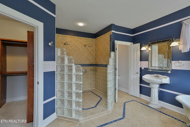 full bath with baseboards, a walk in shower, and tile patterned floors