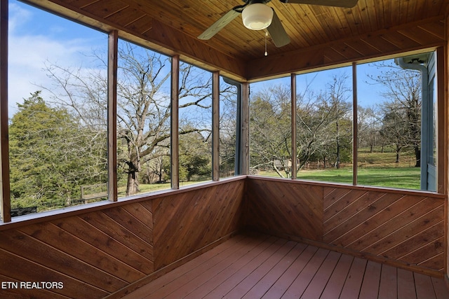 unfurnished sunroom featuring wood ceiling and ceiling fan
