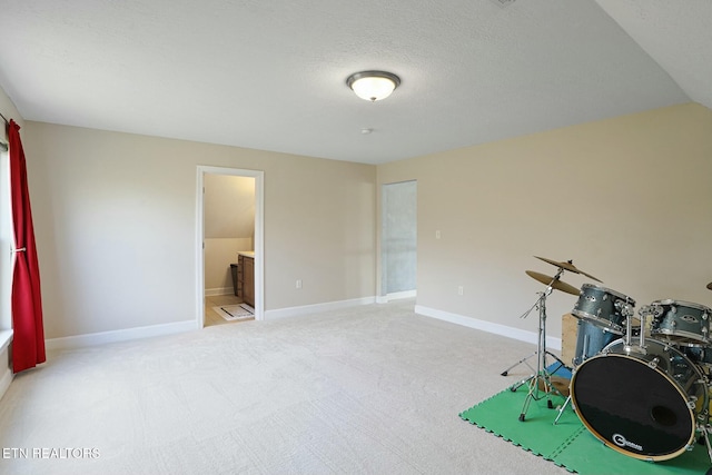 rec room with a textured ceiling, carpet, and baseboards