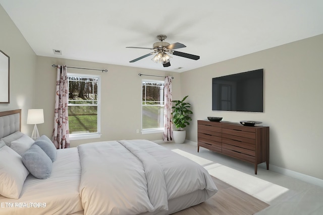 bedroom with light carpet, baseboards, visible vents, and a ceiling fan
