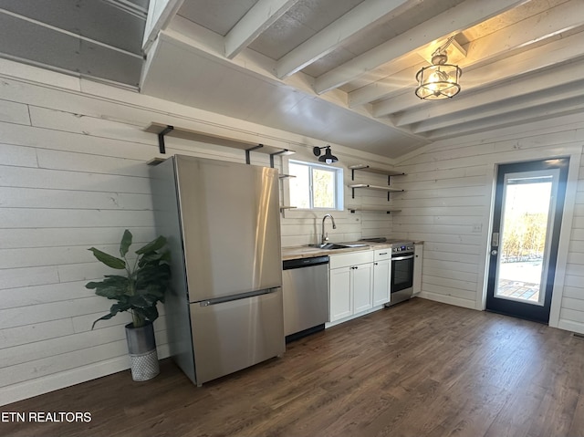 kitchen with white cabinets, appliances with stainless steel finishes, vaulted ceiling with beams, and dark hardwood / wood-style floors