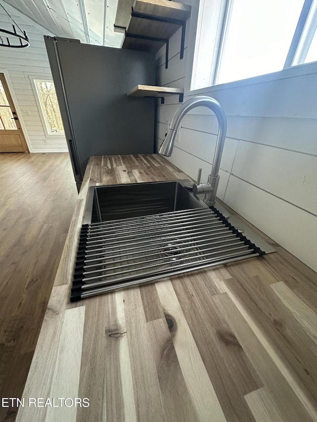 interior details with hardwood / wood-style floors and wood walls