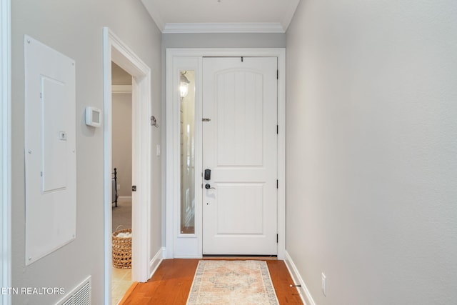 doorway with light hardwood / wood-style flooring and crown molding